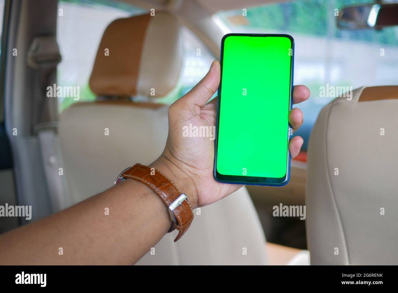 Mann Hand hält Smartphone in einem Auto Stockfoto