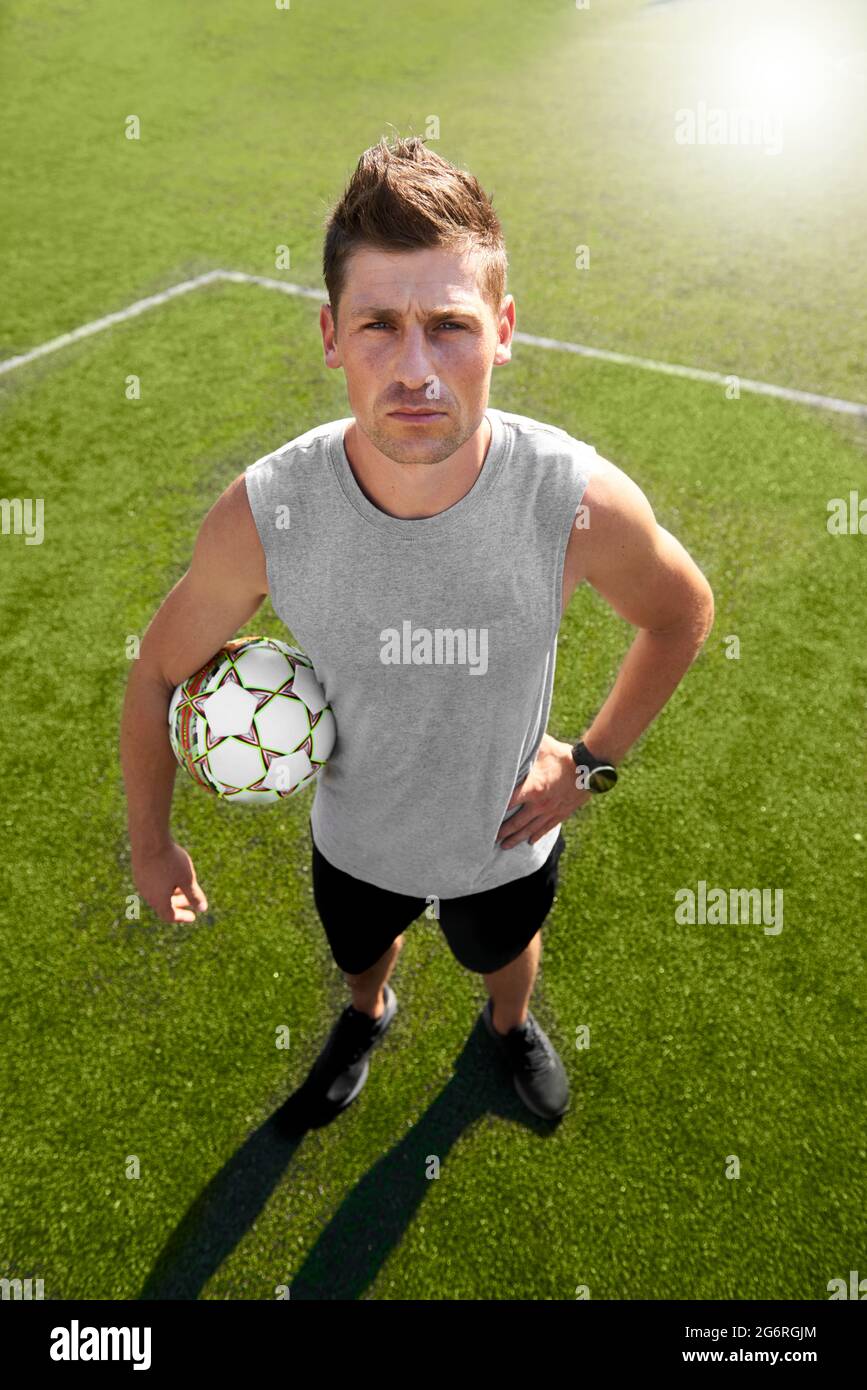 Fußballspieler mit einem Ball, der auf dem Spielfeld steht Stockfoto