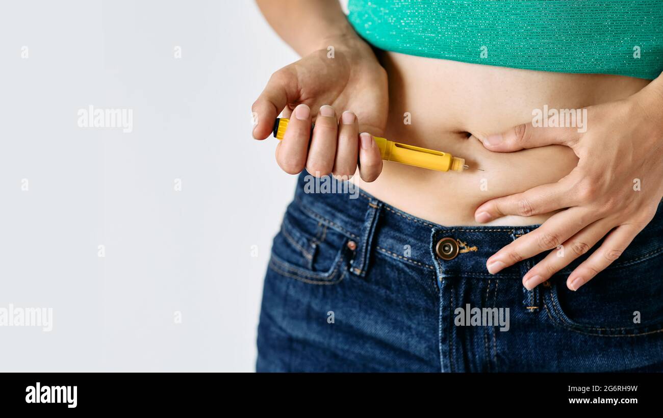 Injektion von Insulin in den Bauch einer Frau, Nahaufnahme. Diabetikerin, die Insulin-Stift verwendet, gibt sich Insulin-Injektion in ihren Bauch Stockfoto