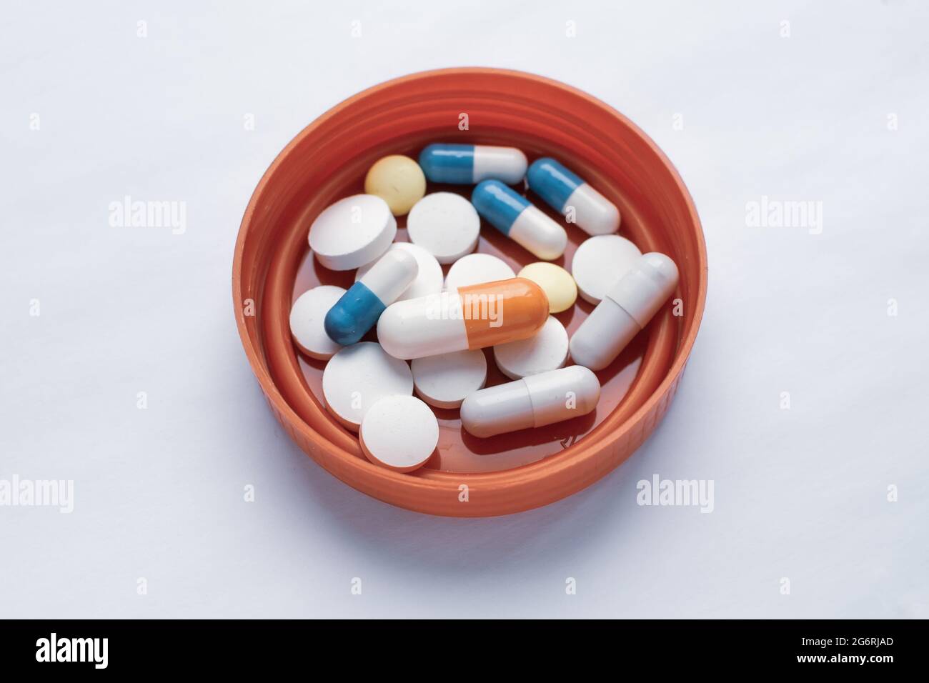 Tabletten und Pillen sind auf dem Deckel des Testglases, verbrauchen eine Menge Pillen Konzept Stockfoto