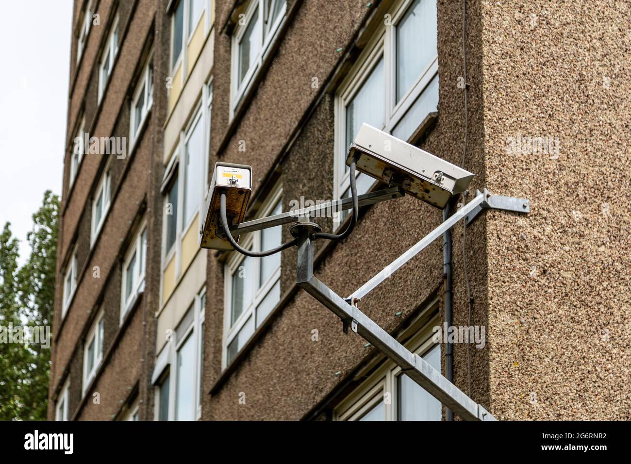 CCTV-Kameras auf der Seite eines Wohnblocks in einem Gebiet mit hohen Kriminalitätsraten Stockfoto