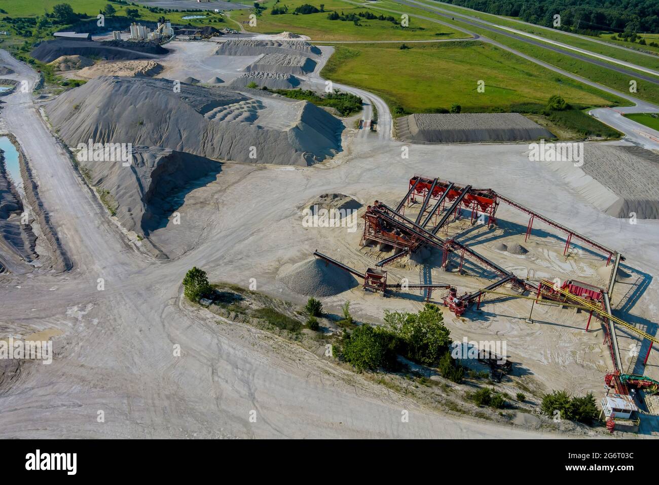 Luftaufnahme des Panorama-Steinbruchs im Tagebau mit vielen Maschinen an Arbeitsgeräten in einer Anlage Stockfoto