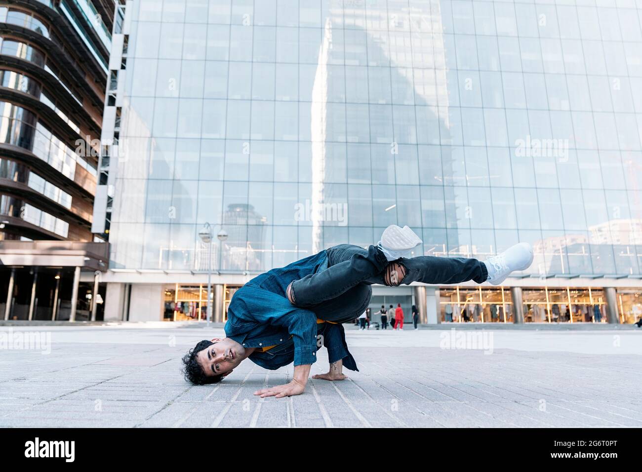 Coole Breakdancer, die auf der Straße üben und Spaß haben. Er tanzt und schaut in die Kamera. Stockfoto
