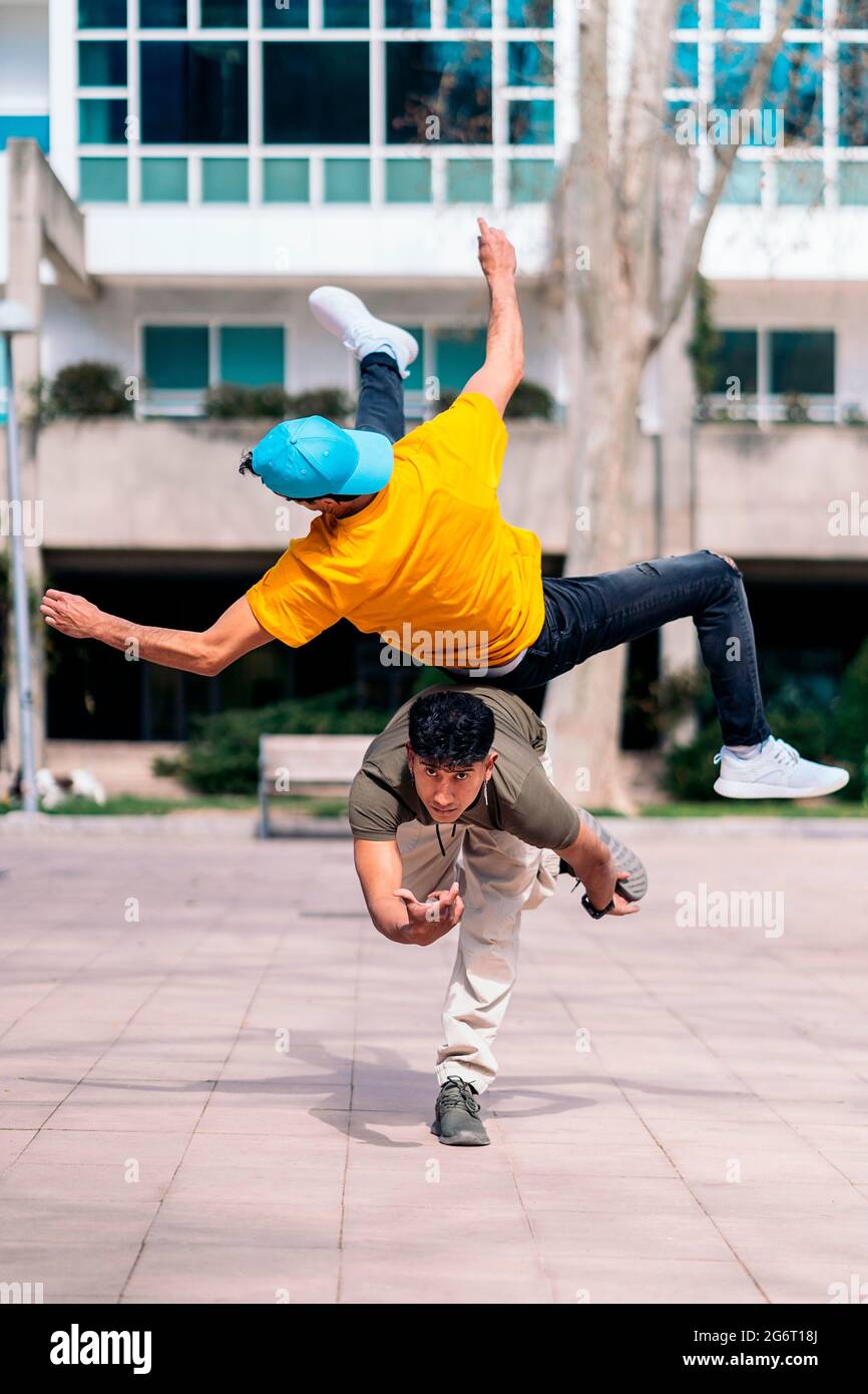 Zwei multiethnische Freunde tanzen im Park und machen Breakdance-Moves. Stockfoto