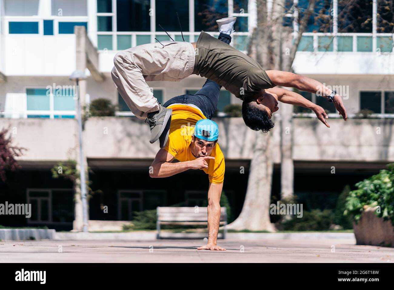 Zwei multiethnische Freunde tanzen im Park und machen Breakdance-Moves. Stockfoto