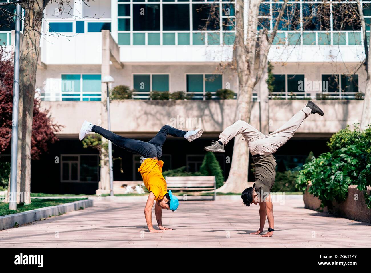 Zwei multiethnische Freunde tanzen im Park und machen Breakdance-Moves. Stockfoto