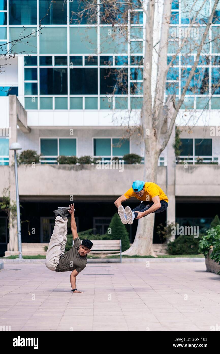 Zwei multiethnische Freunde tanzen im Park und machen Breakdance-Moves. Stockfoto