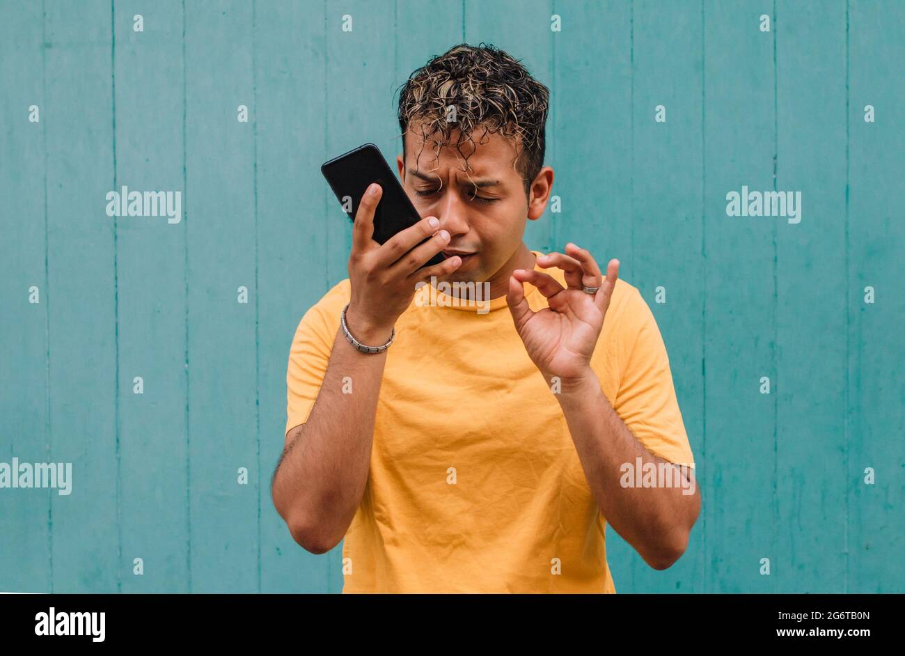 Latino-Typ, der eine Sprachnachricht auf dem Handy sendet Stockfoto