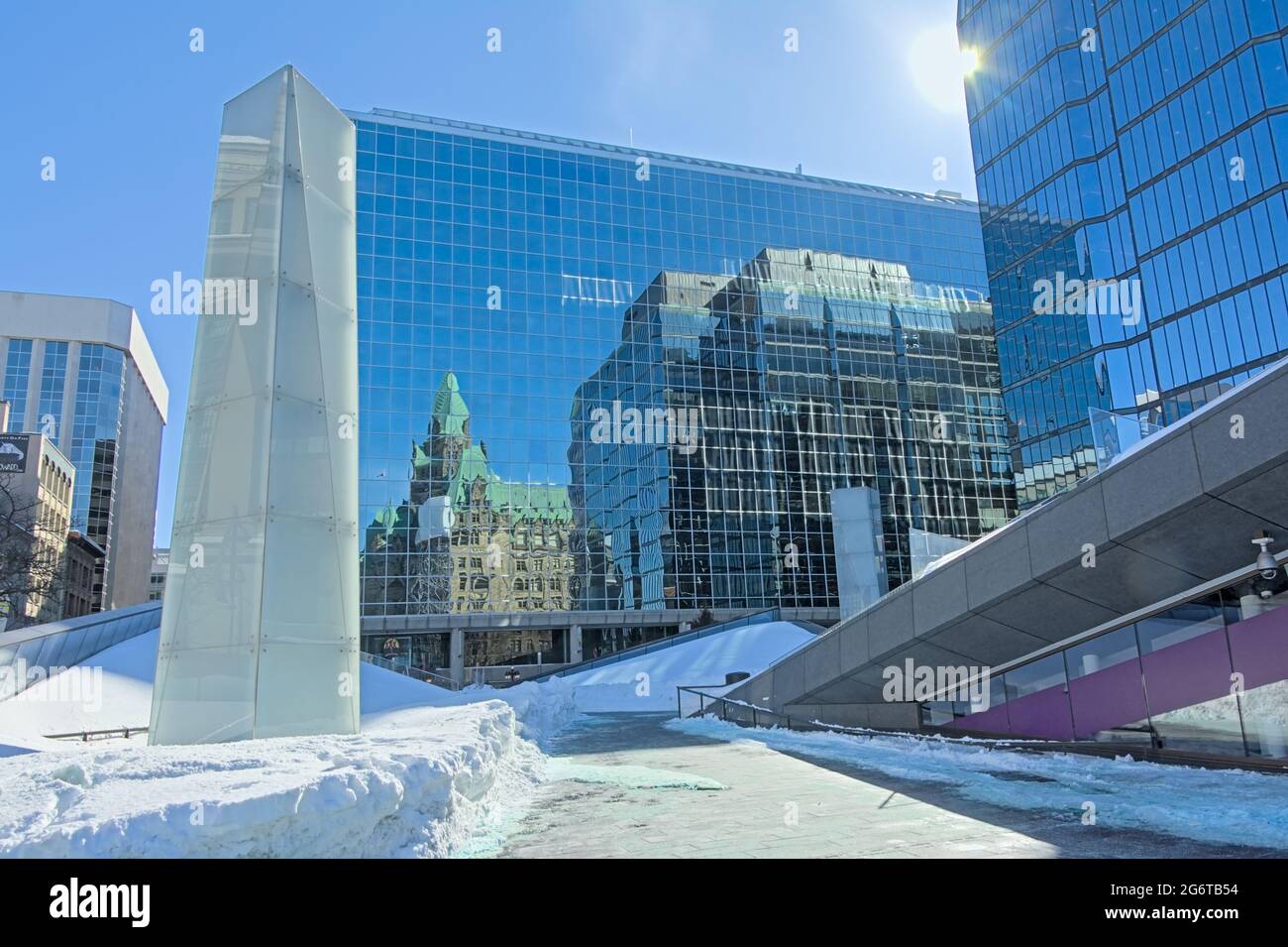 Spiegelung eines traditionellen gotischen Revival-Gebäudes an der Wand eines modernen Bürogebäudes aus Glas und Stahl in Ottawa, Kanada Stockfoto