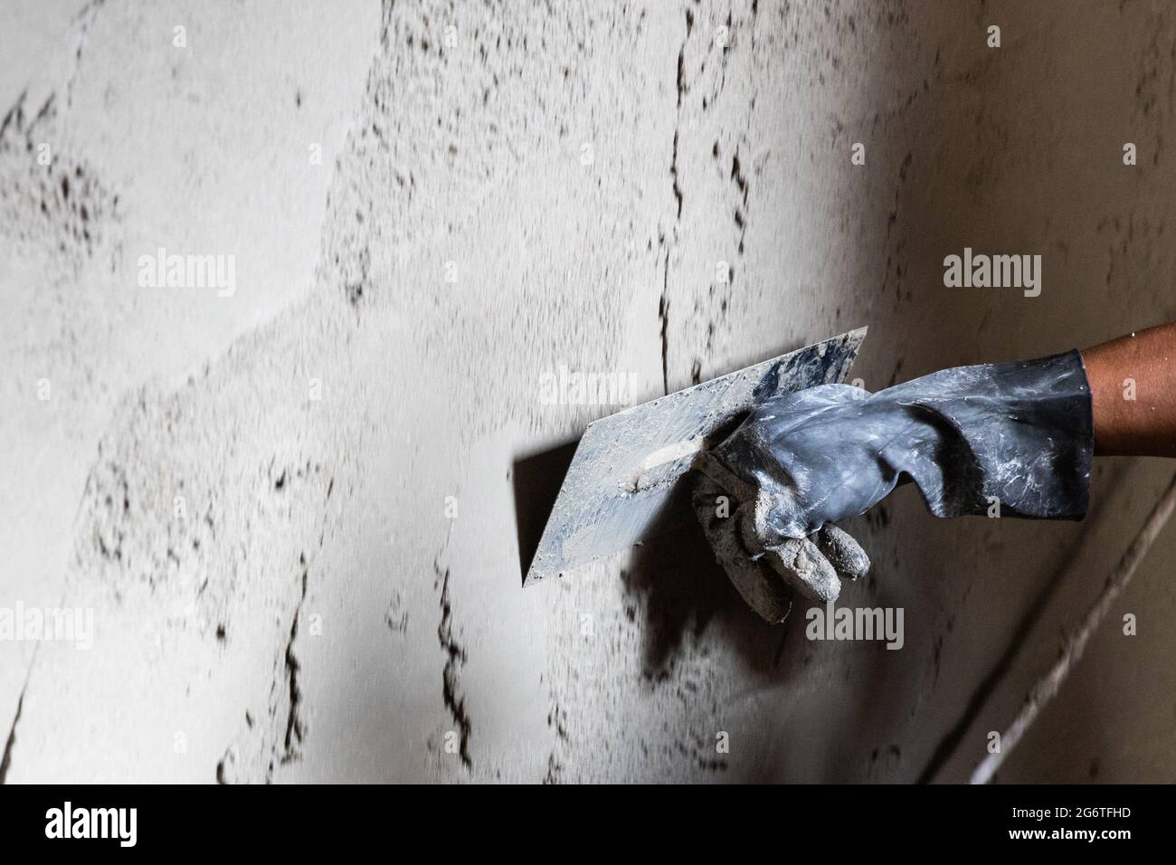 Arbeiter verputzt Zementmörtel auf Betonwand mit Kelle Stockfoto