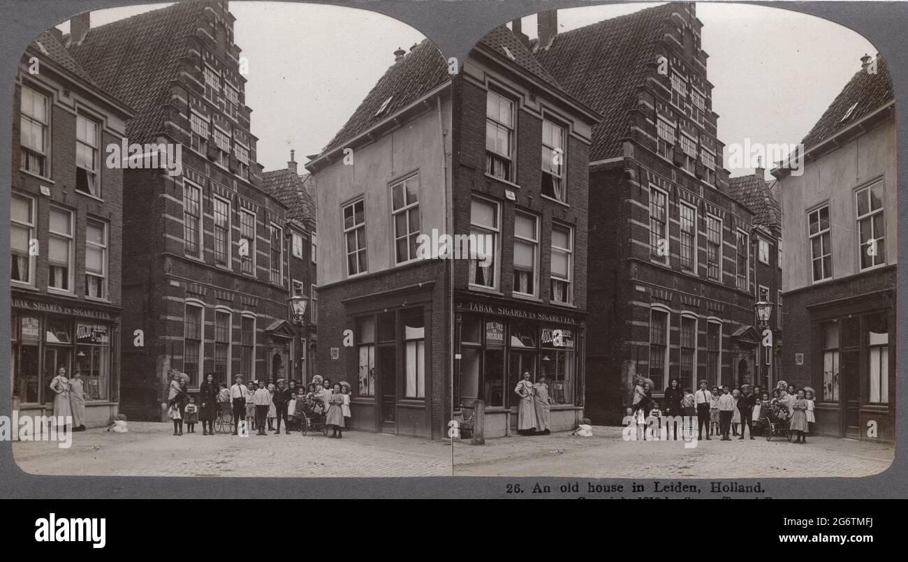 Altstadt Leiden, Holland, um 1910. Das Haus mit dem abgestuften Giebel ist die Lateinschule, in der Rembrandt seine erste Ausbildung erhielt. Links ein Tabakladen mit zwei Damen und einer großen Gruppe von Kindern, die posieren. StereoPhoto der Stereo-Travel co.. Stockfoto