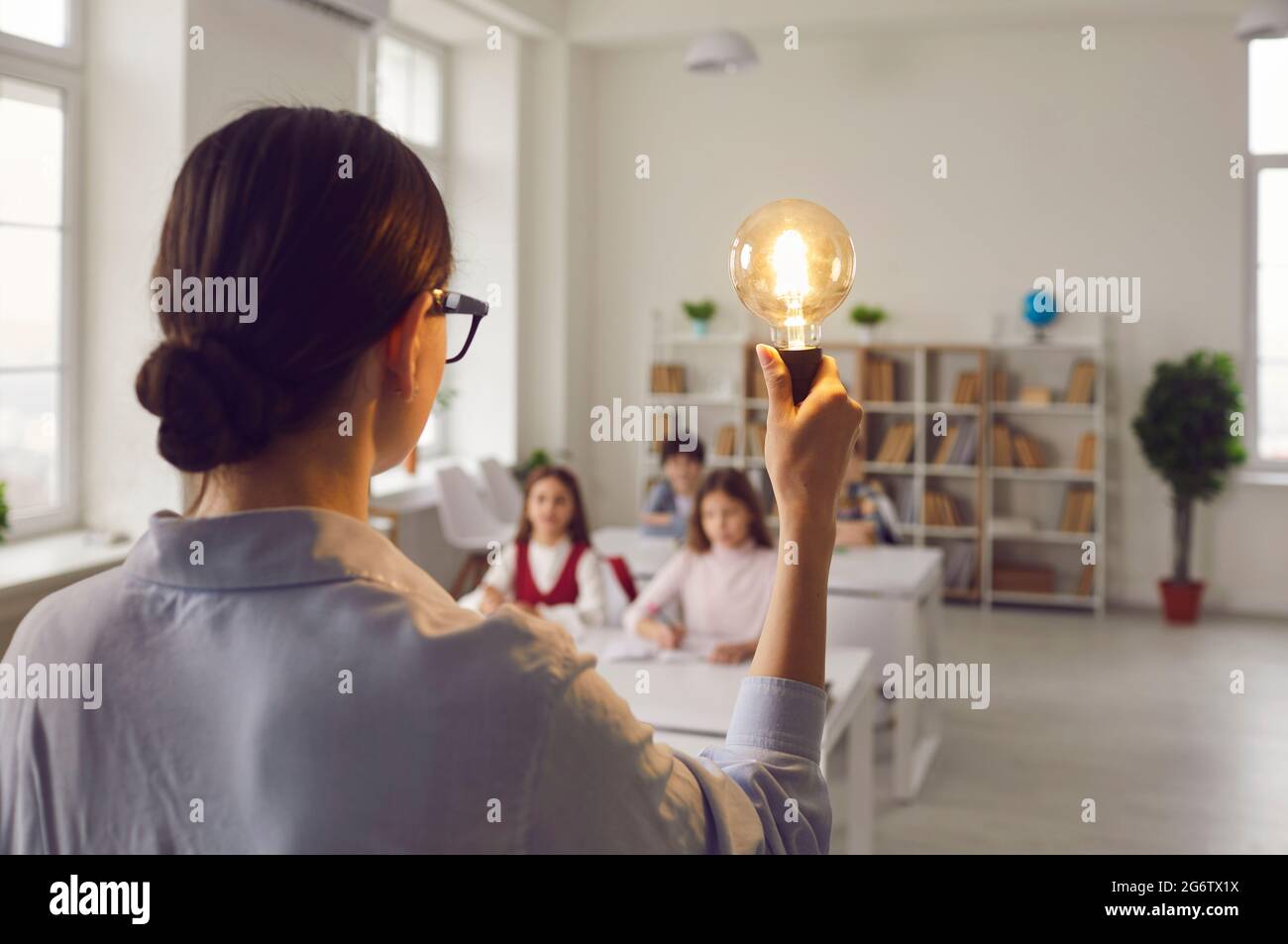 Bester Lehrer mit Idee Glühbirne inspiriert elementare Kinder im Unterricht Stockfoto