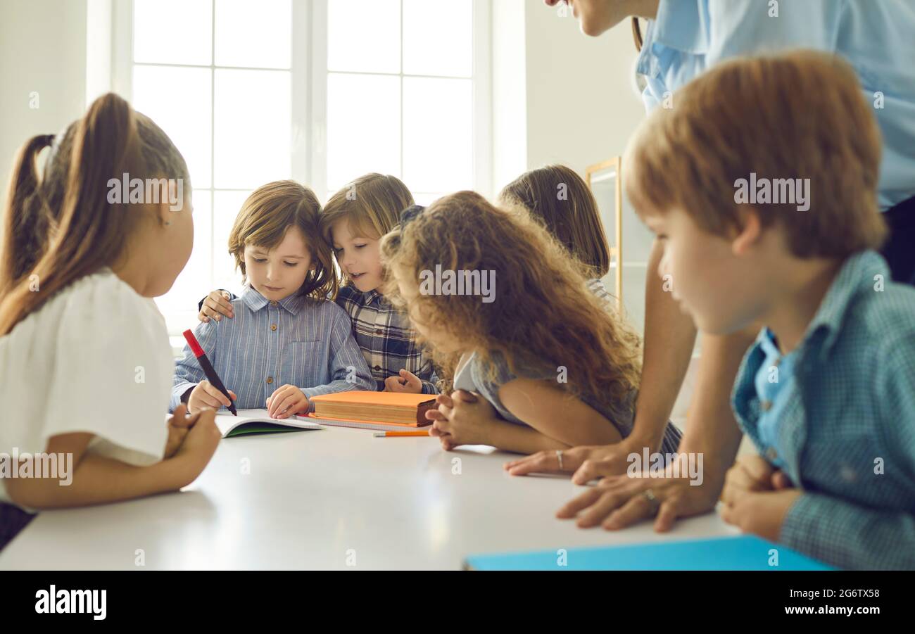Schüler lernen, schreiben, kommunizieren und helfen sich gegenseitig im Klassenzimmer Stockfoto