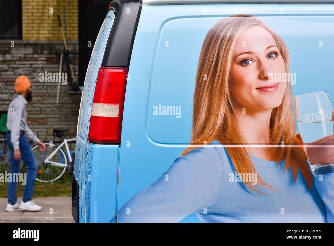 Hindu-Mann, der neben einer Werbung läuft, Montreal, Kanada Stockfoto