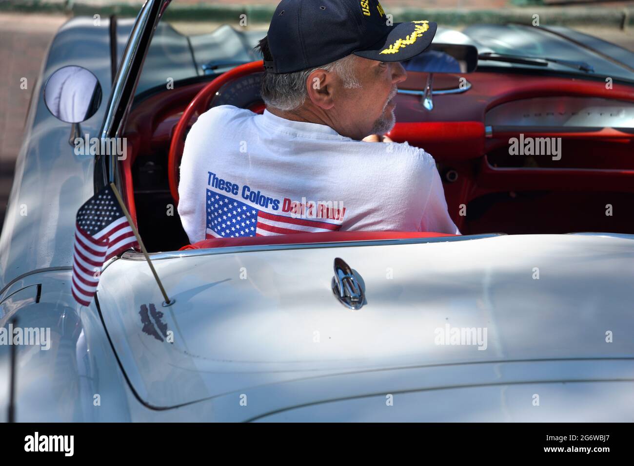 Der amerikanische Besitzer eines Corvette Cabriolets aus dem Jahr 1959 trägt ein patriotisches T-Shirt auf einer Oldtimer-Show am 4. Juli in Santa Fe, New Mexico. Stockfoto