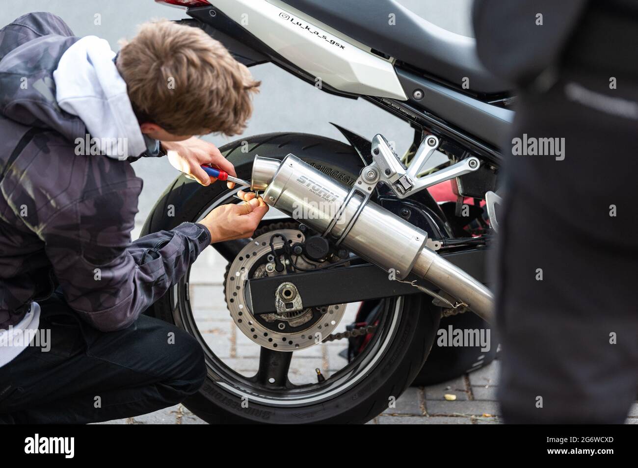 Hannover, Deutschland. Juli 2021. Ein Mann montierte während einer Polizeikontrolle einen sogenannten dB-Killer auf seinem Motorrad. Zwei Tage lang haben Polizeibeamte in Hannover gegen sogenannte Autoposer gehandelt. In den letzten zwei Jahren hat es eine Zunahme von Beschwerden über Fahrer gegeben, die ihre Motoren drehen, um ihre leistungsstarken Autos zu zeigen. Quelle: Philipp Schulze/dpa/Alamy Live News Stockfoto