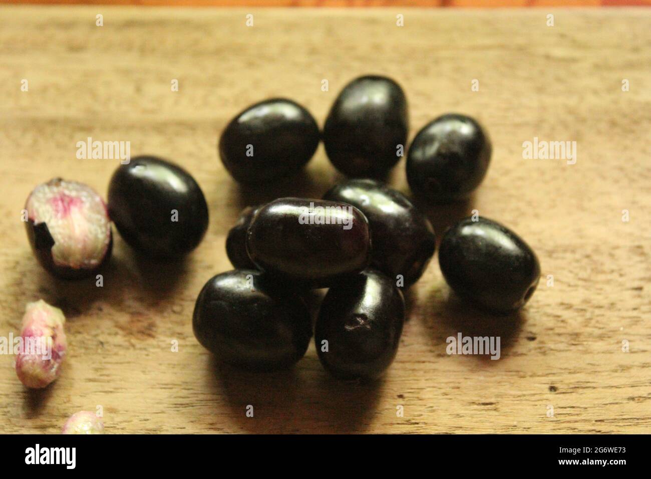 Java-Pflaumenfrüchte oder syzygium-Früchte auf isolierter Holzoberfläche, Draufsicht, blaue Beerenfrucht, neues Bild Stockfoto