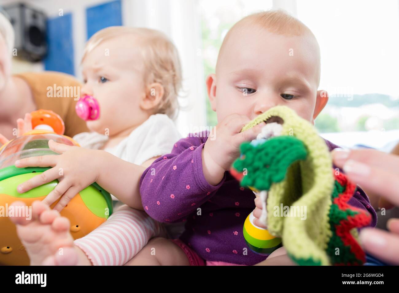 Babys mit Schnuller in Toddler Gruppe mit Spielzeug spielen Stockfoto