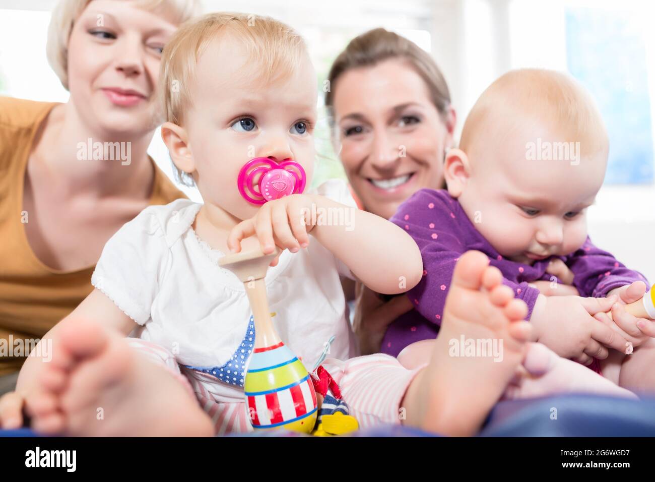 Babys mit Schnuller in Toddler Gruppe mit Spielzeug spielen Stockfoto