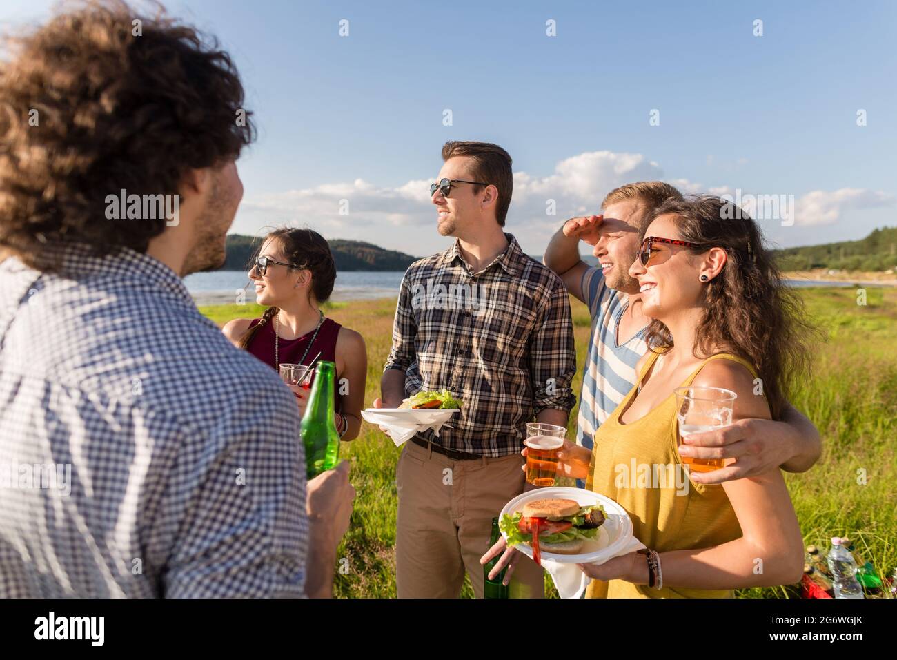Gruppe von Freunden mit typischen Menü der Sommer-Grillparty, Burger und Bier Stockfoto