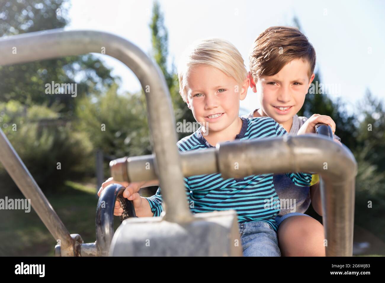 Zwei Jungen mit Bagger auf Abenteuerspielplatz im Park Spaß haben Stockfoto