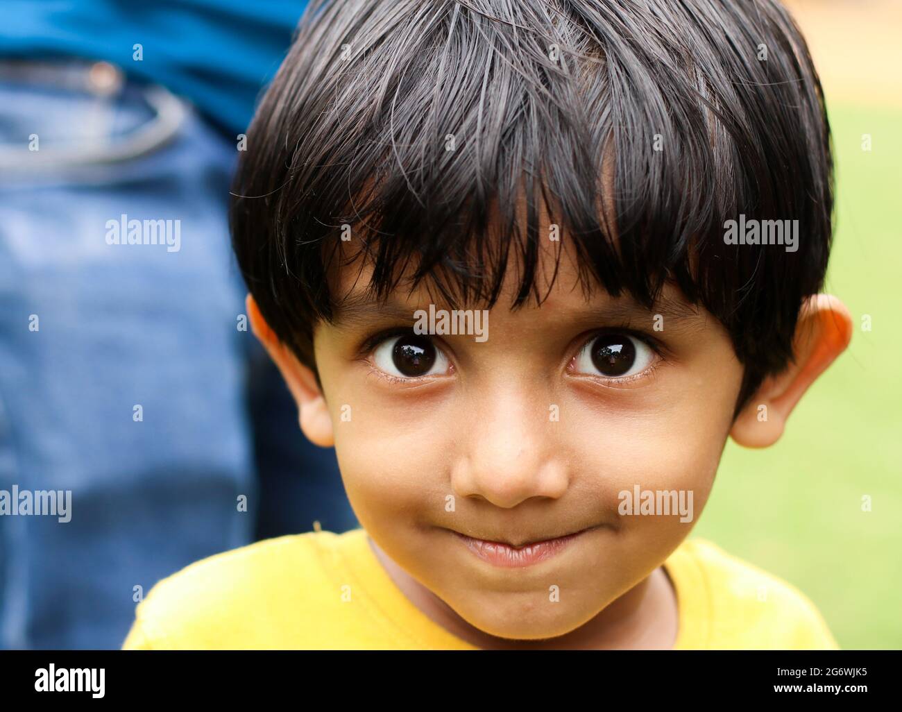 Porträt eines niedlichen kleinen Jungen mit seidig glattem Haar, das über seine Stirn fällt Stockfoto