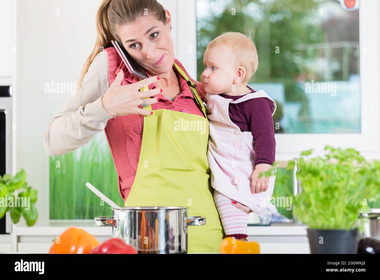Die Mama von Hausarbeit, Kochen betonte, Vorbereitung, Arbeit, Handy und Kinder Stockfoto
