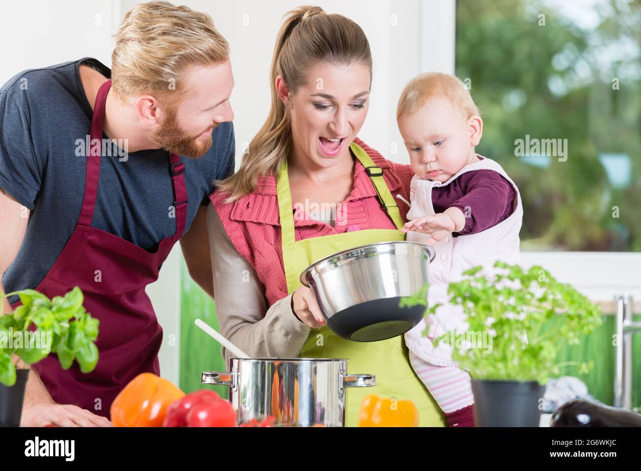 Mama, Papa und Kind in der Küche Essen probieren Stockfoto