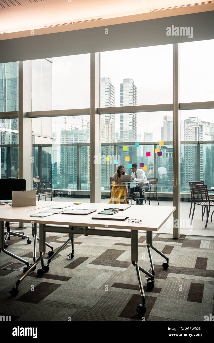 Modernes, leeres Büro mit transparenten Glaswänden zur Terrasse mit drahtloser Verbindung Stockfoto