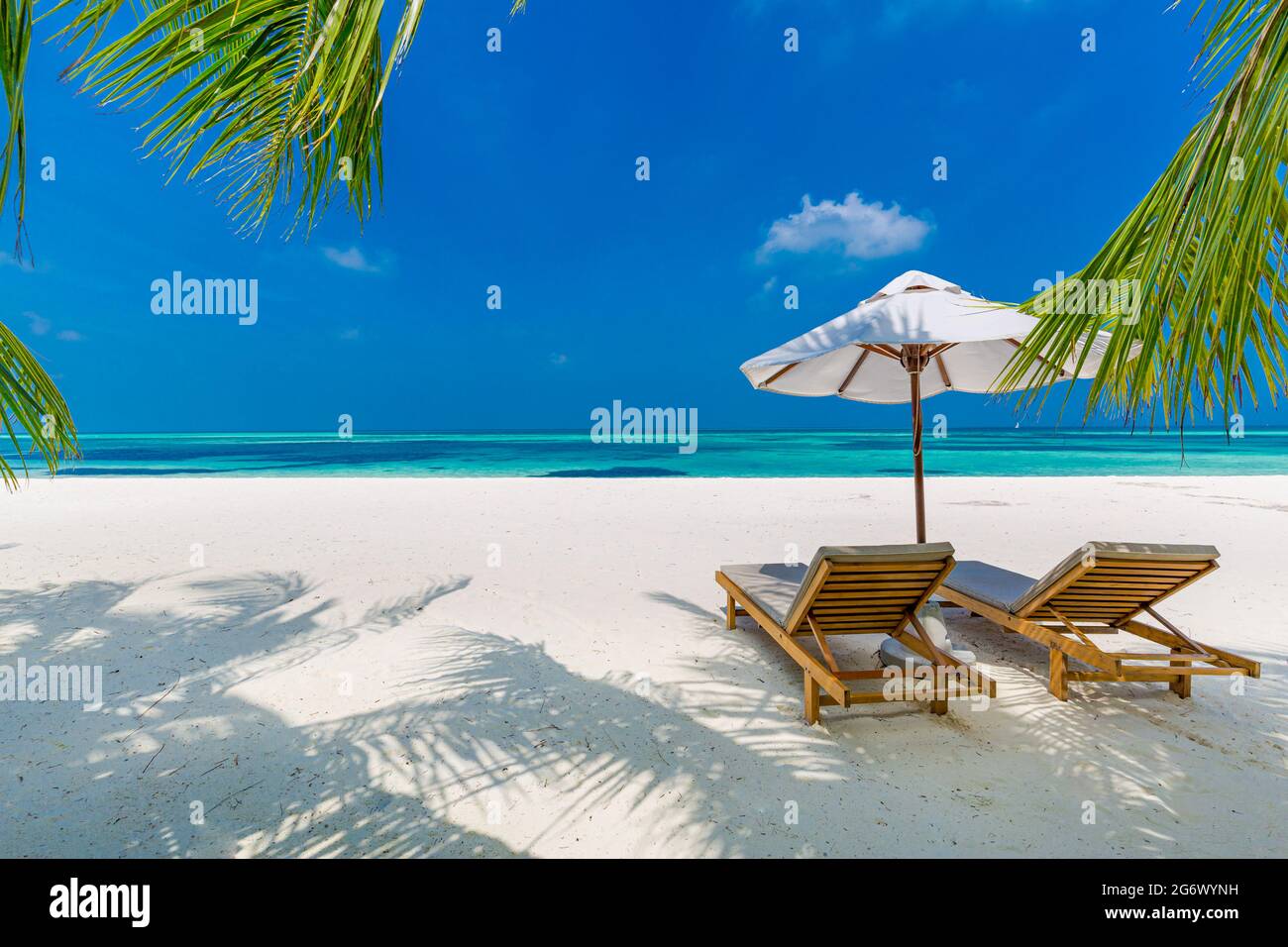 Tropische Strandnatur als Sommerlandschaft mit Liegestühlen und Palmen und ruhiges Meer für Strandbanner. Luxuriöse Reise Urlaub Urlaubslandschaft Stockfoto