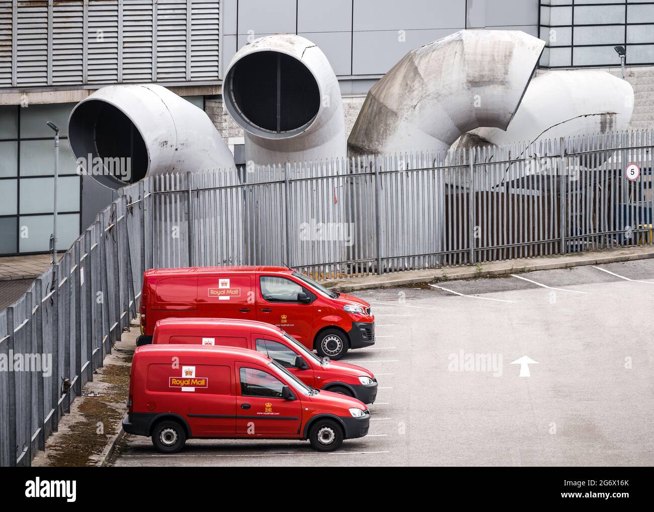 Sheffield South Yorkshire 5.7.2021 leuchtend rote königliche Briefwagen parkten vor seltsamen, großen, modernen Gebäudehüffrohren. Streikenden Postdienst Stockfoto