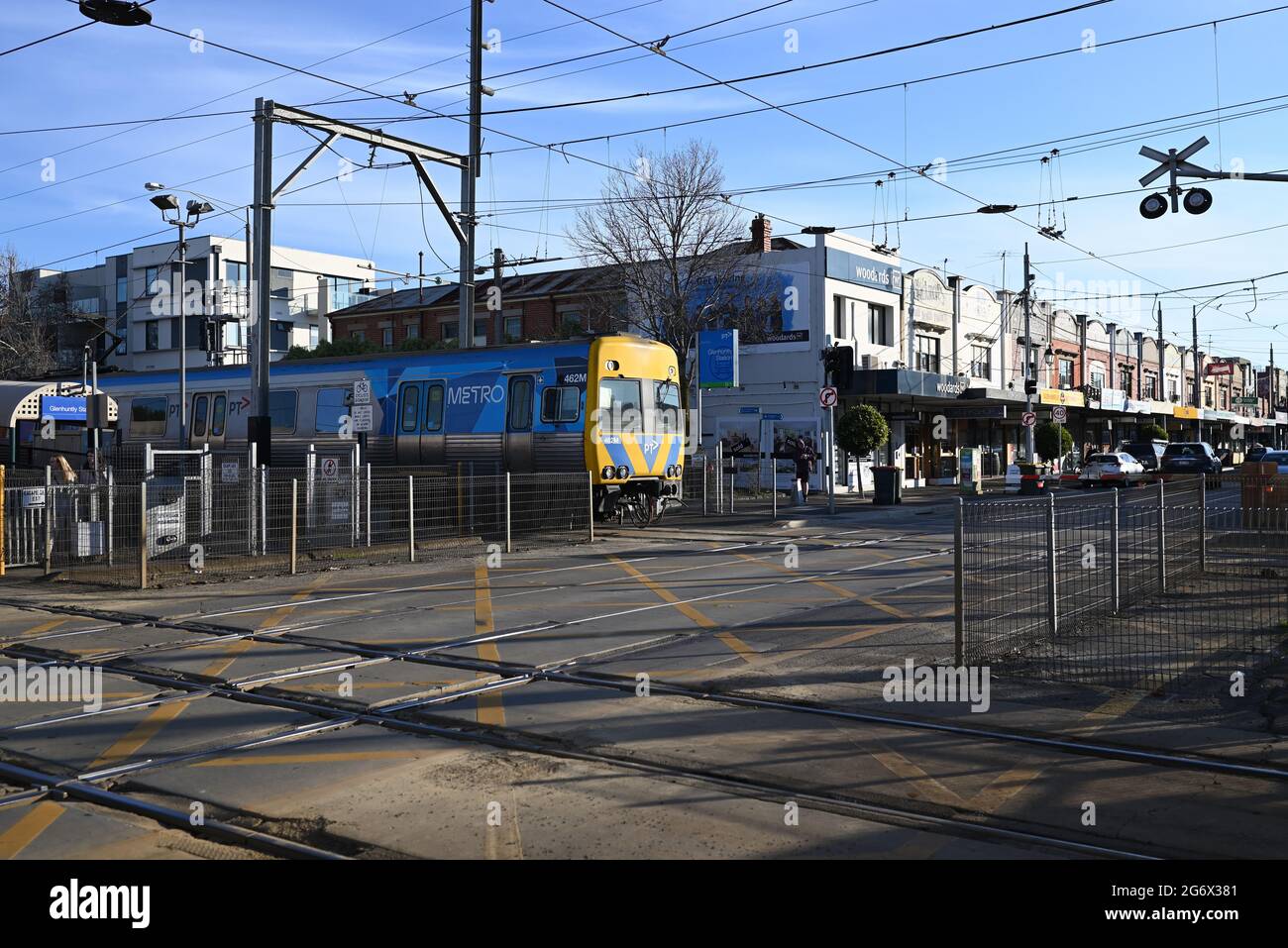 Ein Comeng-Zug, der von den Metro-Zügen Melbourne betrieben wird, überquert den Bahnübergang Glen Huntly Rd, wenn er den Bahnhof Glenhuntly verlässt Stockfoto