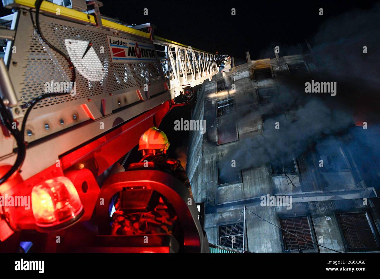 Die Feuerwehrleute versuchen, das Feuer im Gebäude zu löschen, nachdem in einer Fabrik namens Hashem Foods Ltd in Rupganj im Bezirk Narayanganj am Stadtrand von Dhaka ein Feuer ausgebrochen ist. Mindestens drei Menschen wurden getötet, 20 weitere verletzt und viele werden nach einem massiven Brand in einer Fabrik in die Falle getappt. Die Ursache des Feuers, der im Erdgeschoss eines mehrstöckigen Gebäudes der Fabrik ausging, ist noch nicht bekannt. Stockfoto