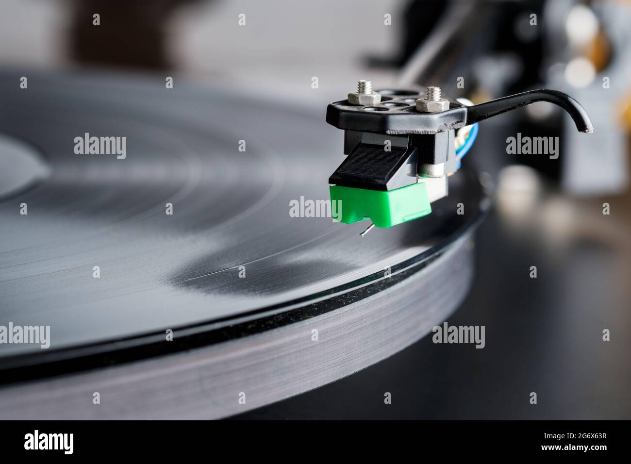 Ein Plattenspieler-Stylus wird auf eine Platte oder LP auf einem Hifi-Plattenspieler fallen. Die Nadel des Eingabestifts ist deutlich sichtbar und die Aufzeichnung dreht sich Stockfoto