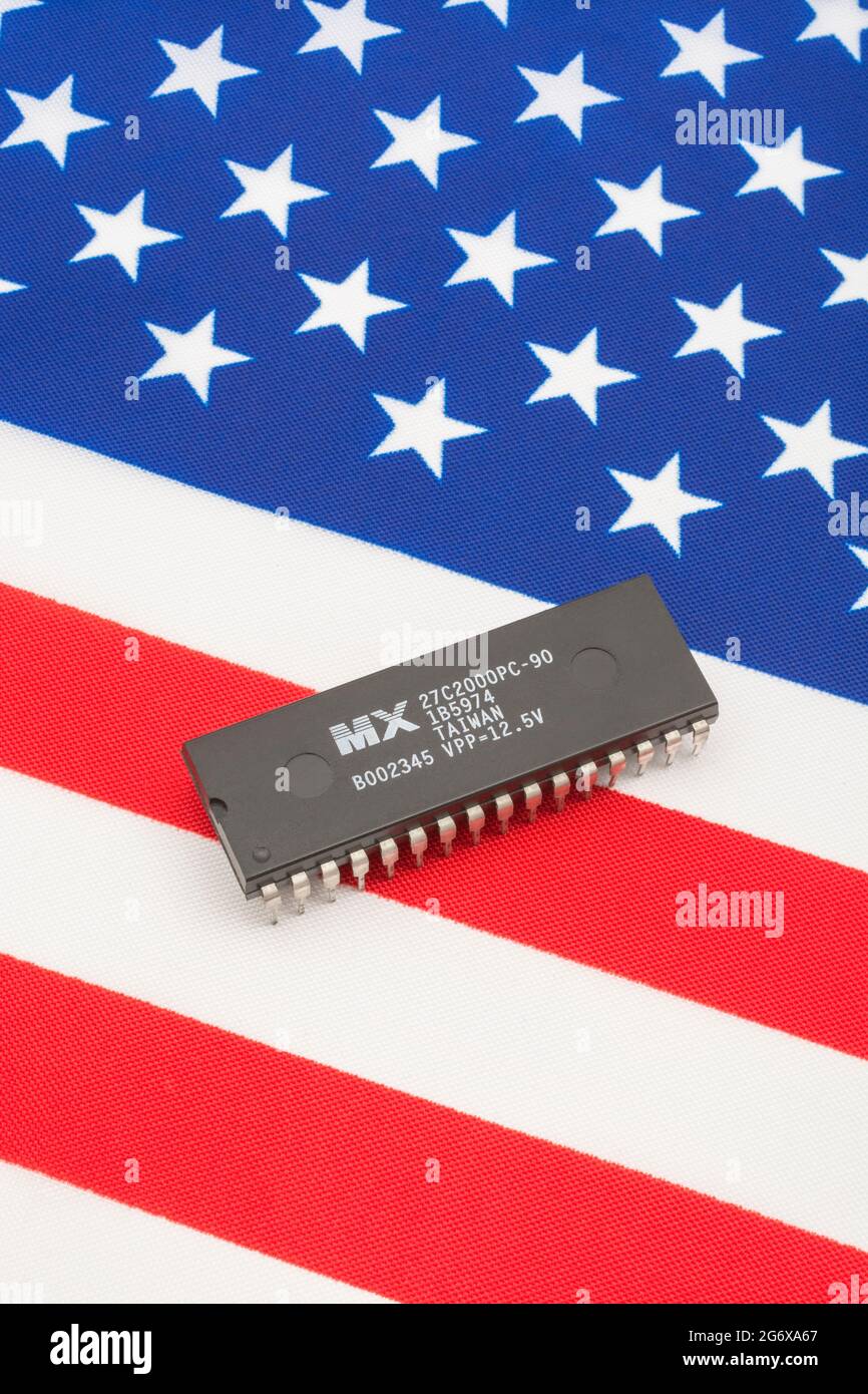 Nahaufnahme von Macronix International Integrated Circuit / EPROM Chip auf kleiner US Stars & Stripes Flagge. Für US-Halbleiterknappheit im Jahr 2021. Stockfoto