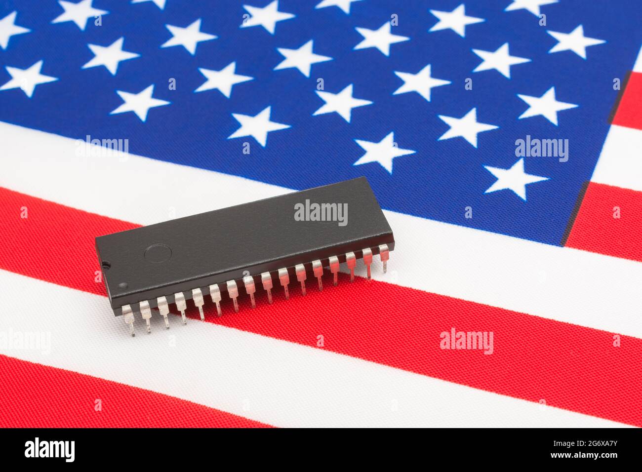 Nahaufnahme des integrierten Schaltkreises/EPROM-Chips auf der kleinen US-Flagge Stars & Stripes. Für US-amerikanische Halbleiter-Start-ups, die selbst entwickelte amerikanische Chip-Vormachtstellung. Stockfoto