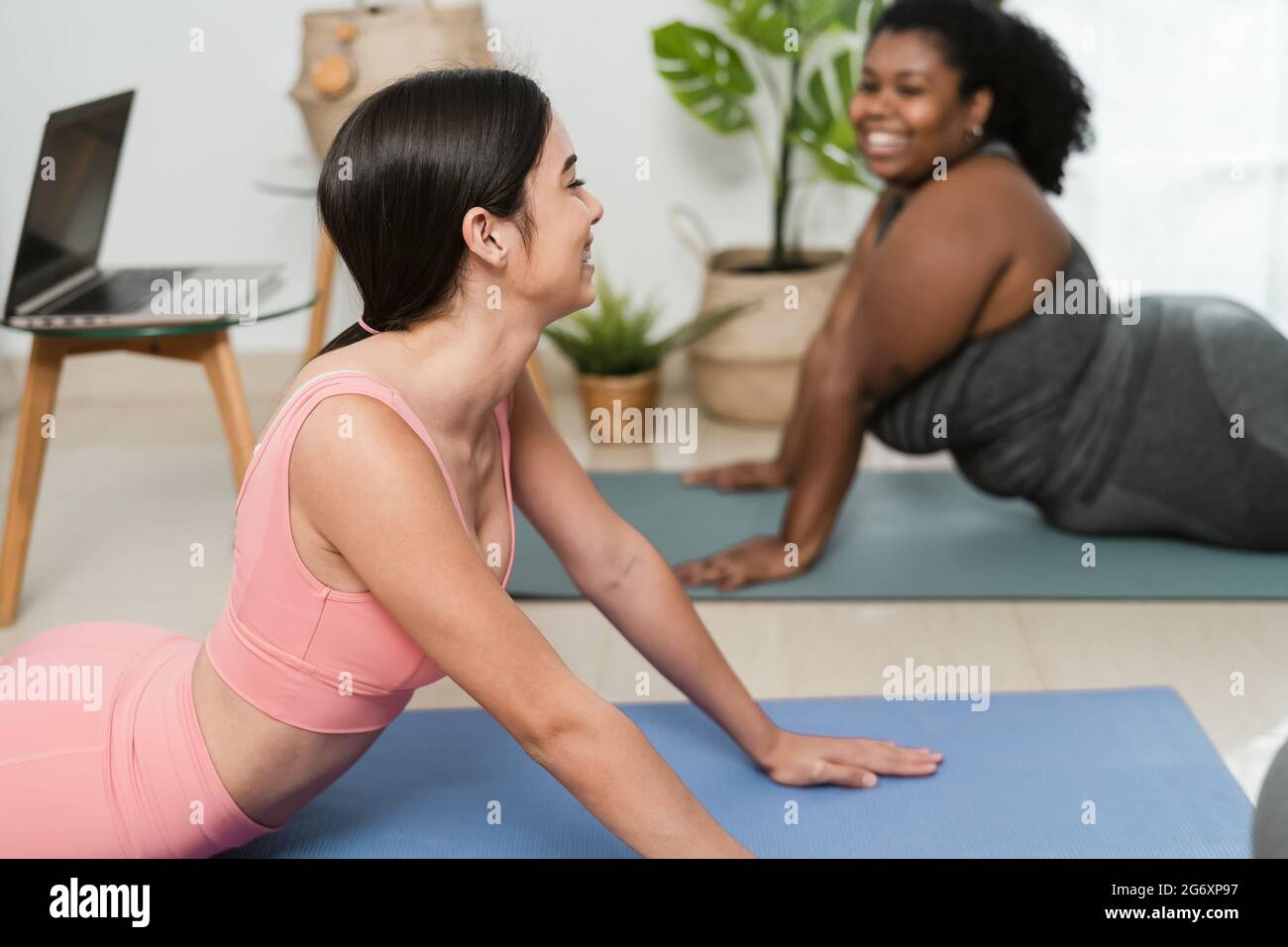 Junge Lateinerinnen machen Yoga und Pilates-Übungen zu Hause - Sport Wellness Lifestyle Konzept Stockfoto