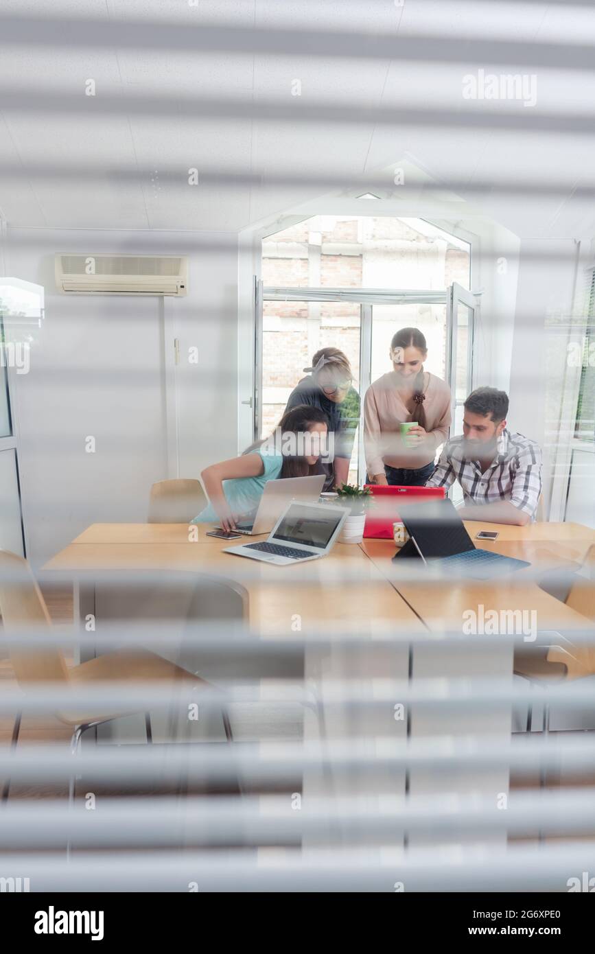 Nahaufnahme der transparente Fenster eines Büros mit drei Jungen selbständigen Teilen die Ausstattung eines modernen Co-Arbeitsbereich Stockfoto