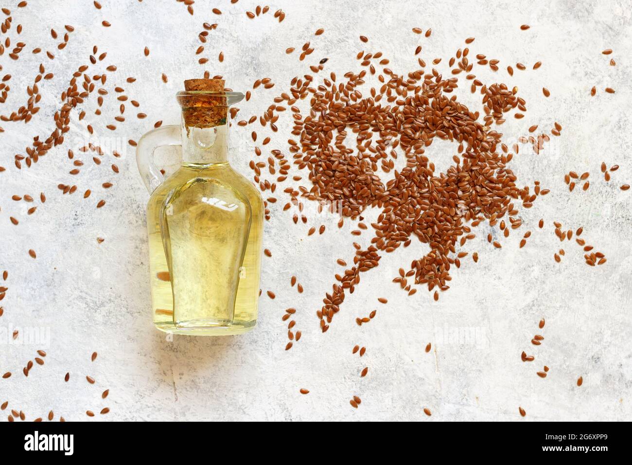 Rohe Leinsamen Öl und Samen mit einem Löffel Draufsicht auf weißem Tisch Stockfoto