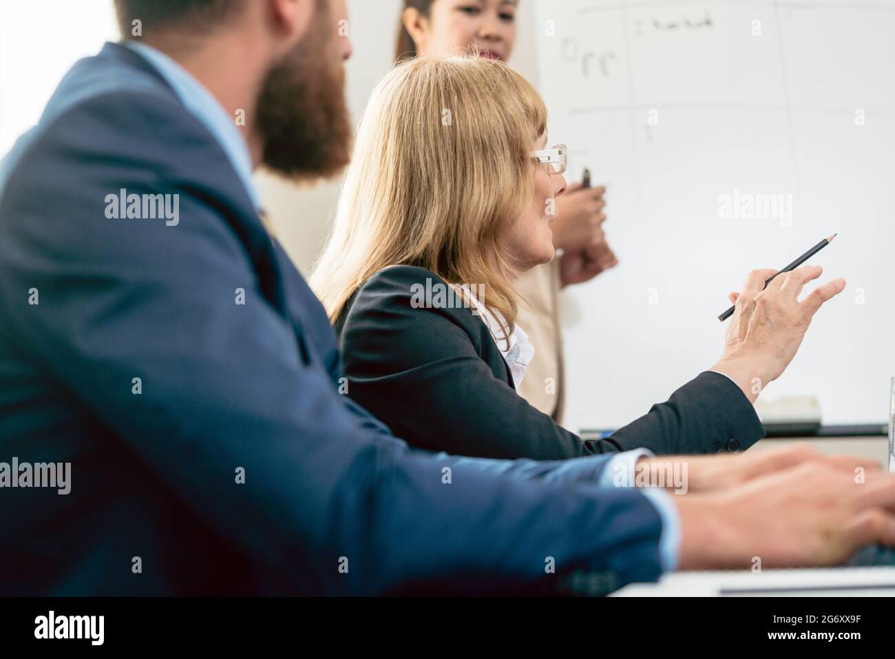Seitenansicht eines mittleren Alters business Frau ihre Vision und Meinung über ein Projekt präsentieren während einer Entscheidungsfindung Tagung im Konferenzraum Stockfoto