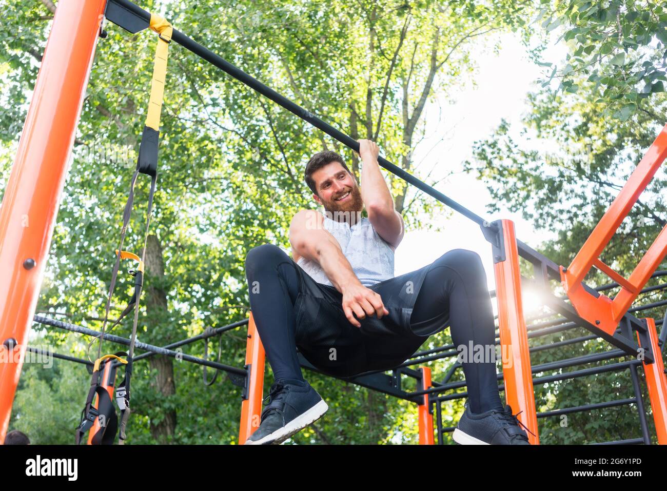 Aus der Perspektive eines starken jungen Mannes, der einarmige Pull-Ups macht, während er während des extremen Trainings in einem modernen Calisthenics-Park an einer Bar hängt Stockfoto