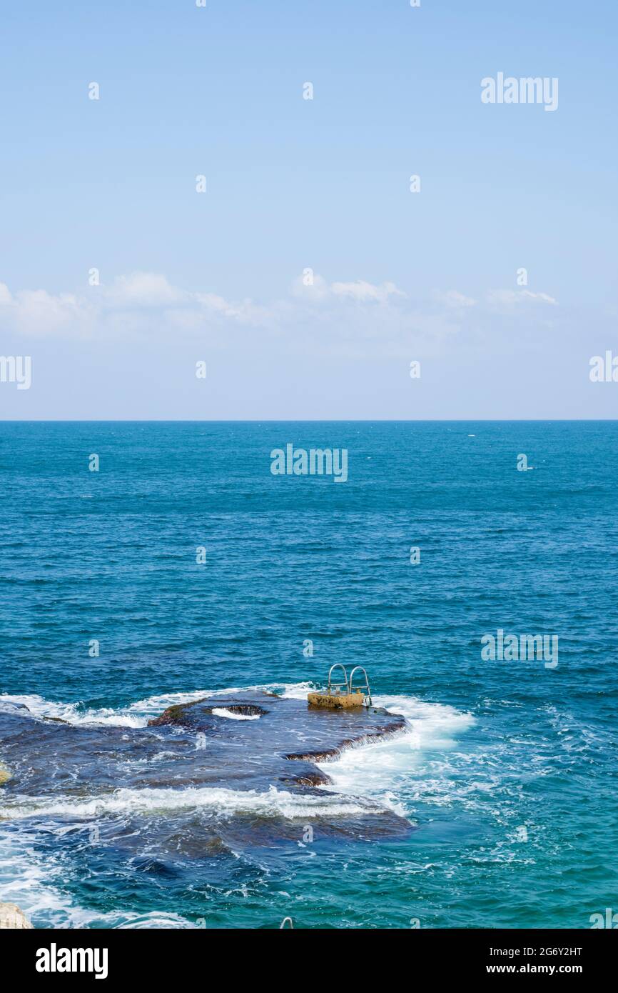 Haltegriffe und Leiter, die auf einem natürlichen Felsen auf See in Beirut, Libanon, installiert sind Stockfoto