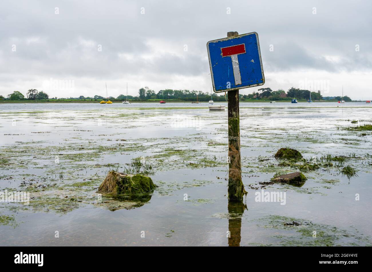 Kein Durchgangsschild auf einer überfluteten Straße bei Flut, wo die Straße regelmäßig in Bosham, West Sussex, England, Großbritannien, überflutet wird. Stockfoto