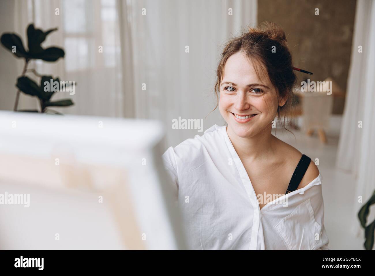 Porträt einer lächelnden Frau, die im Kunststudio malt Stockfoto