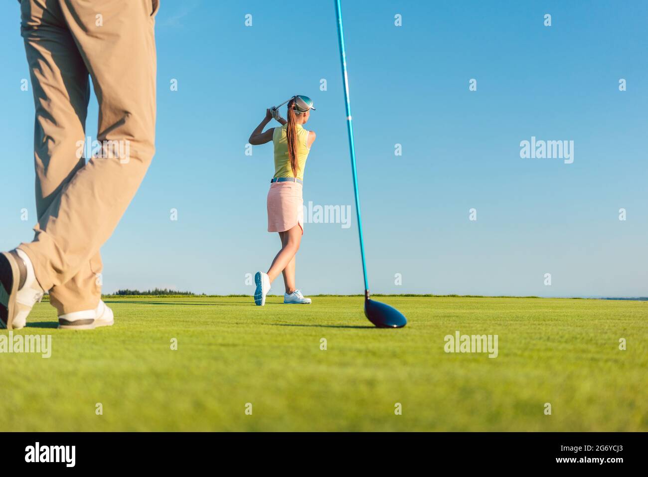 Low-Angle-Ansicht in voller Länge von einer weiblichen professionellen Golferin, die einen langen Schuss während eines anspruchsvollen Matchplay-Spiels für zwei Spieler im Freien in einer Sonne trifft Stockfoto