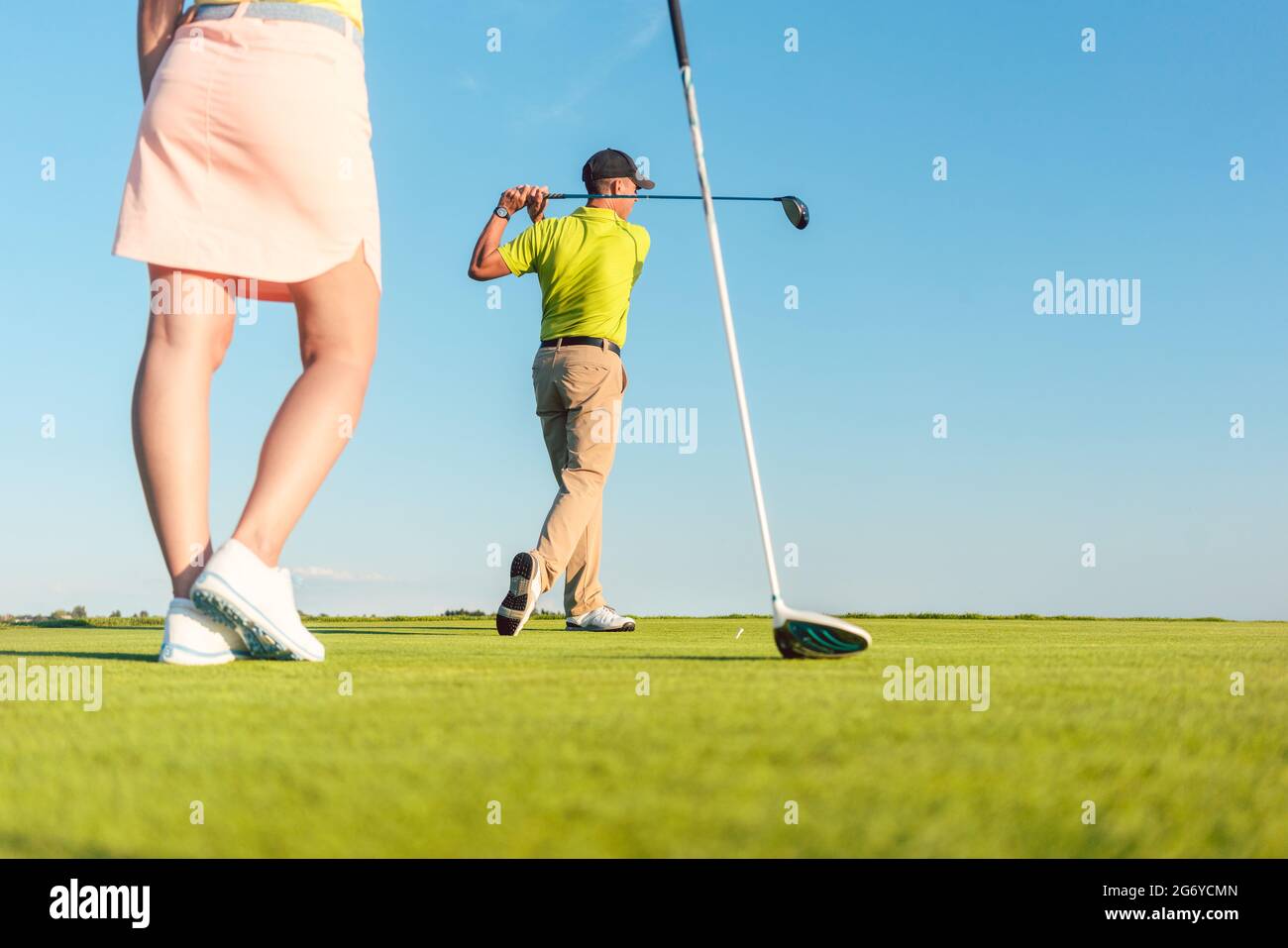 Low-Angle-Ansicht in voller Länge des Mannes, der mit seiner Partnerin beim Matchplay für zwei Spieler im Freien an einem sonnigen Tag Golf spielt Stockfoto