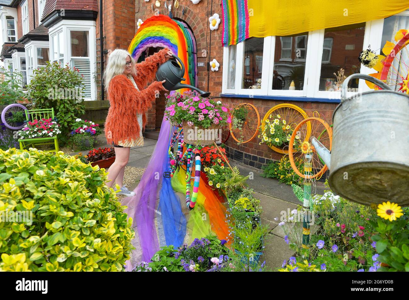 Leicester, Leicestershire, Großbritannien, 9. Juli 2021. UK News. Die Mixed-Media-Künstlerin Alison Zimmerer-Hughes mit ihrer Kunstinstallation ‘Blooming Lovely“ vor ihrem Haus in Aylestone, Leicester. Die Mischung von Textilien und Blumen bringt Farbe und Natur in die Stadt. Das Kunstwerk wurde von Vehicle Arts für das ‘Projekt „Up Your Street“ in auftrag gegeben. Da es im letzten Jahr so einen Mangel an Zugang zu den Künsten gab, ist die Prämisse des Projekts, die Straßen in der Umgebung zu erhellen und die Menschen zu engagieren. Quelle: Alex Hannam/Alamy Live News Stockfoto