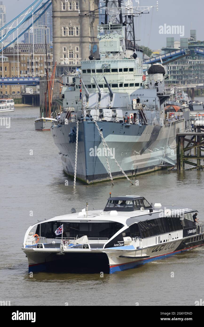 London, England, Großbritannien. Uber Boat / Thames Clipper, nahe der HMS Belfast, Tower Bridge im Hintergrund Stockfoto