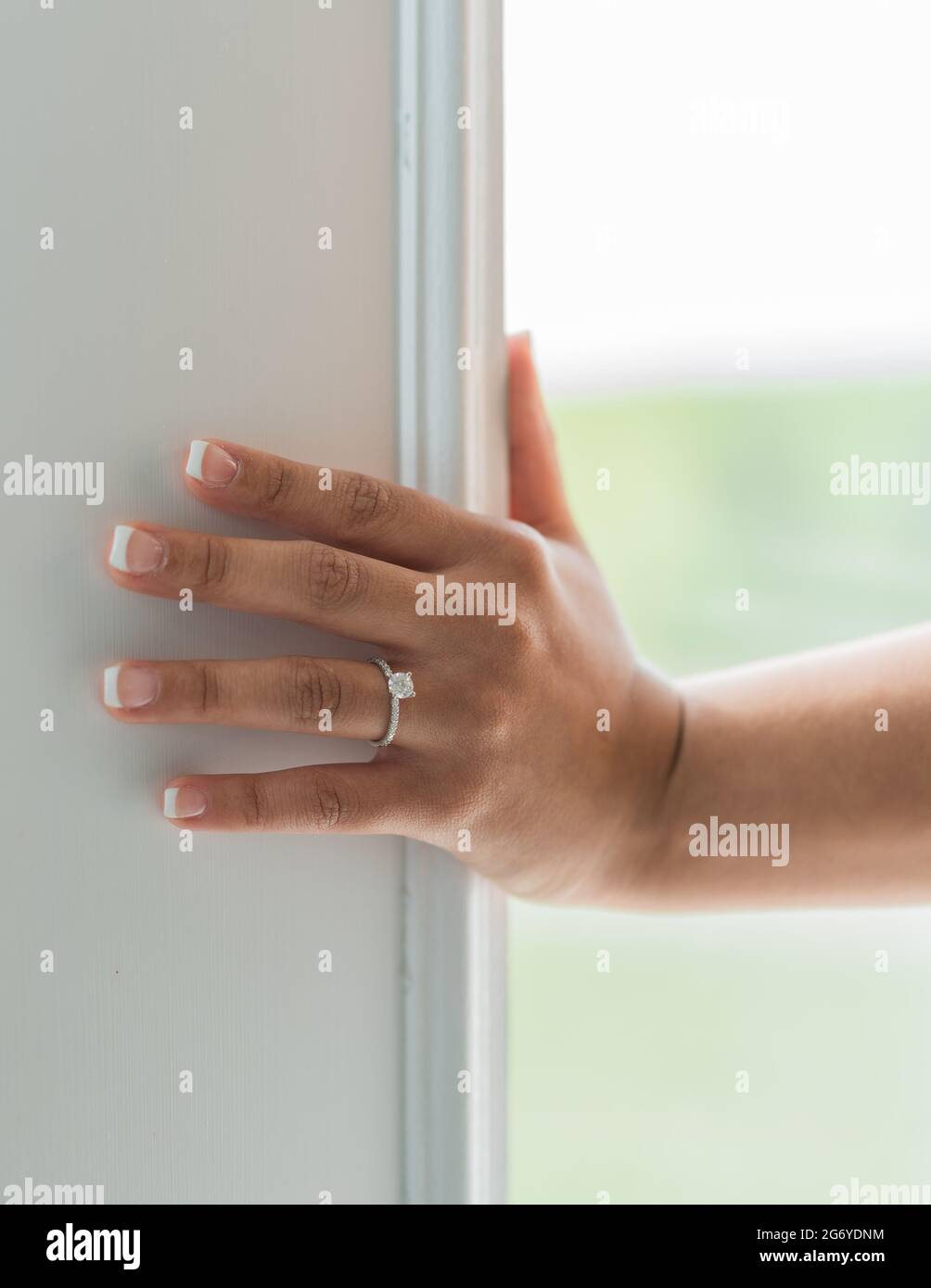 Vertikale Aufnahme der linken Hand eines Weibchens an der Wand mit einem Ring Stockfoto