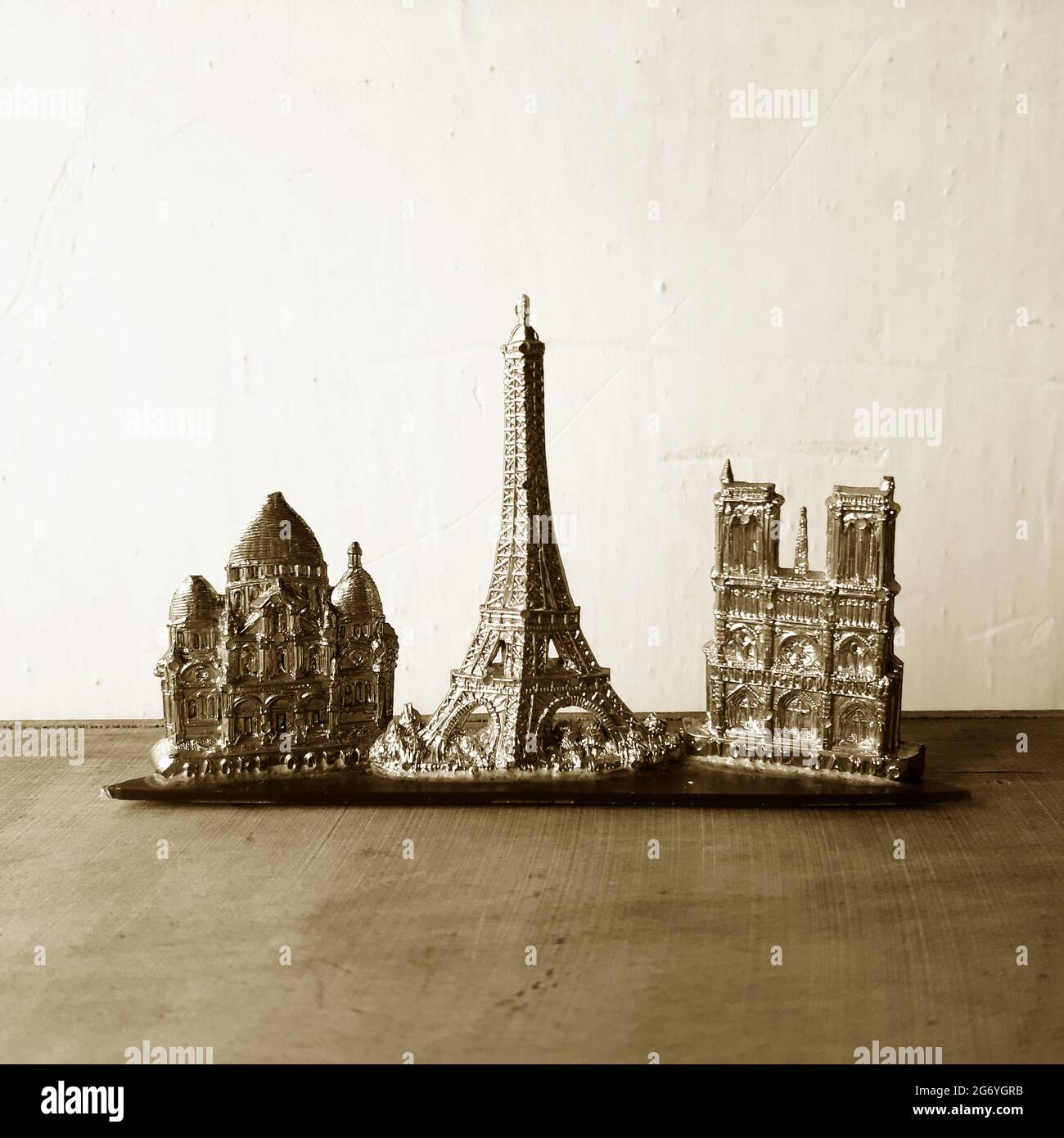 Teil eines alten Pariser Souvenir aus Plastik mit Sacre Coeur, Eiffelturm und Kathedrale Notre Dame, fotografiert in Sepia-Tönen. Stockfoto
